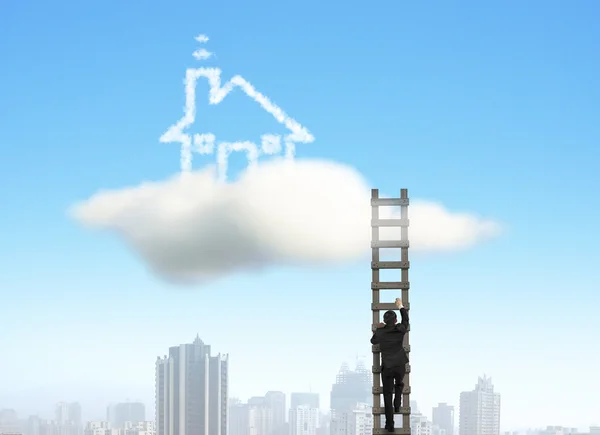 Biznesmen wspinaczka drabiny drewniane chmura dom, miasto pod — Zdjęcie stockowe