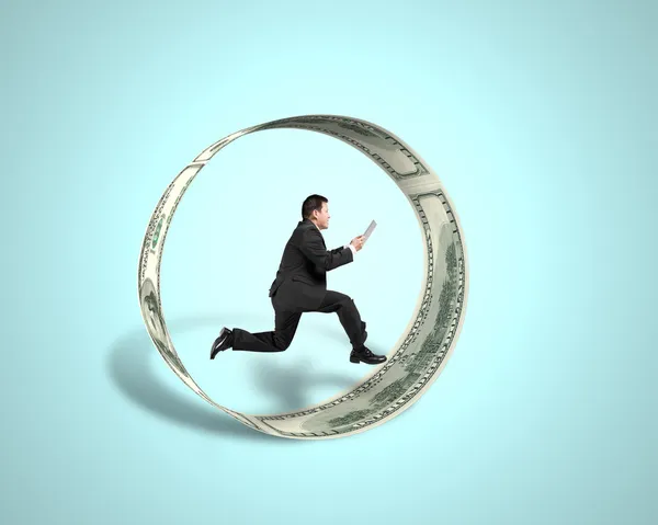 Businessman using tablet running inside money circle in green — Stock Photo, Image
