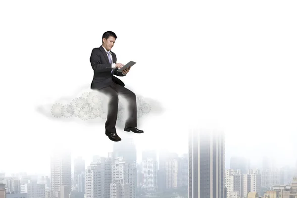 Empresario usando tableta y sentado en la nube — Foto de Stock