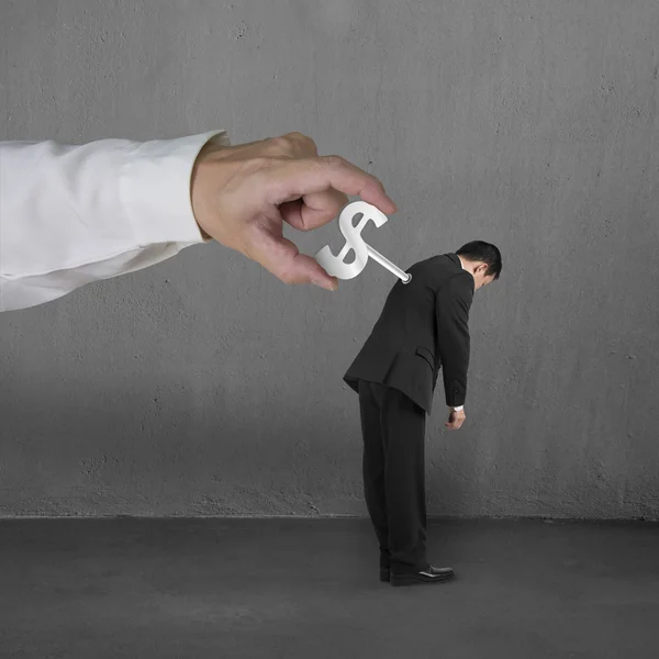 Hand windering winder on businessman's back, concrete background — Stock Photo, Image