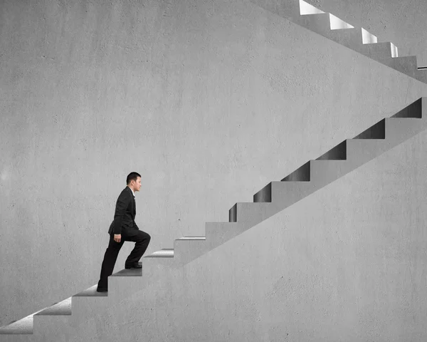 Businessman climbing on concrete stairs — Stock Photo, Image