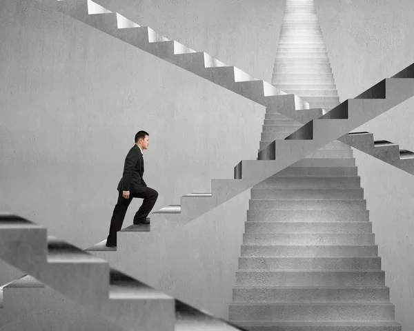 Hombre de negocios escalando en el laberinto de escaleras de hormigón —  Fotos de Stock