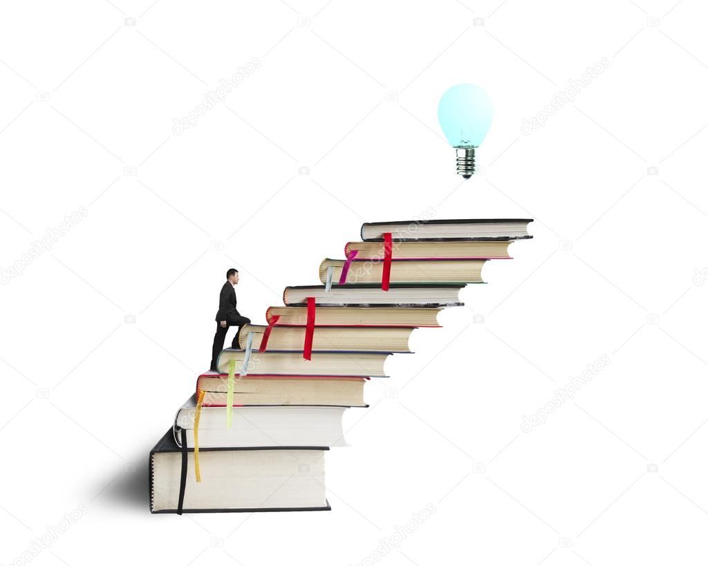 Businessman climbing on stack of books with growing bulb