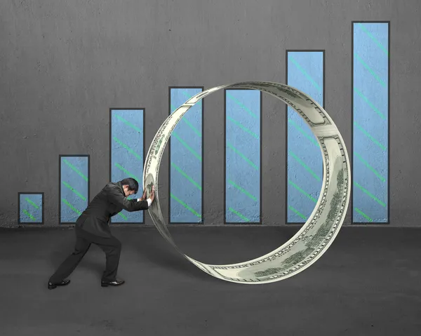 Бизнесмен толкает денежный круг с диаграммой — стоковое фото