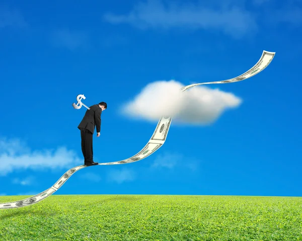 Бизнесмен стоит на растущей денежной тенденции с лугом и небом — стоковое фото