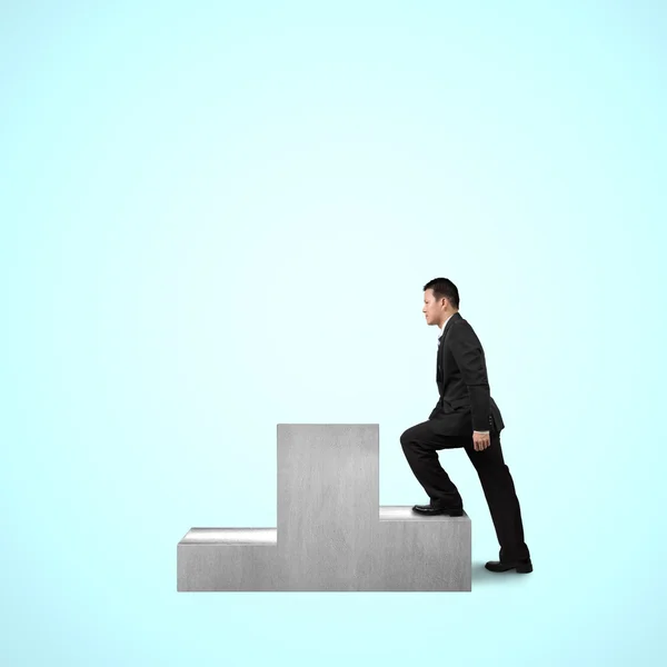 Businessman climbing on podium — Stock Photo, Image