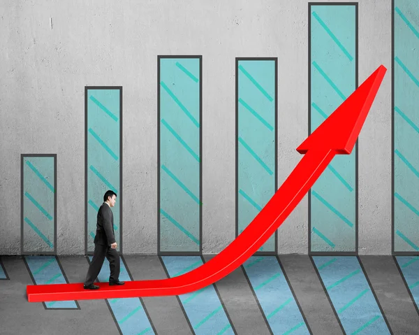 Empresário andando na seta vermelha crescente com gráfico — Fotografia de Stock