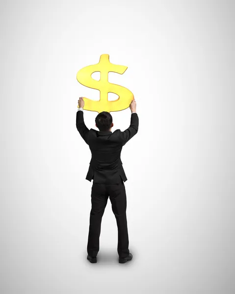 Uomo d'affari tenere 3D simbolo di denaro d'oro — Foto Stock