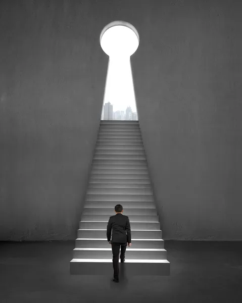 Geschäftsmann zu Fuß auf der Treppe zu Schlüsselform Tür, Blick auf die Stadt — Stockfoto