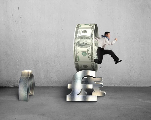 Empresario saltando a través del círculo en la pila de símbolos de dinero —  Fotos de Stock