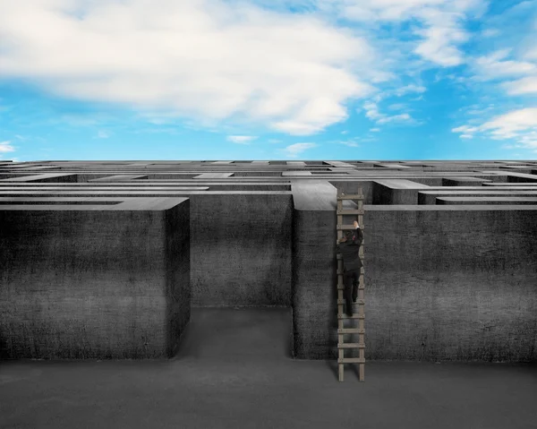 Empresário subindo na escada para o topo da estrutura de labirinto de concreto — Fotografia de Stock