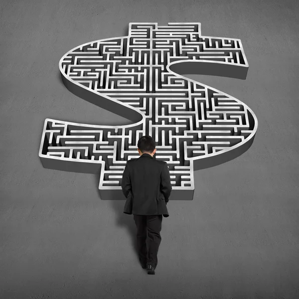 Businessman walking toward to 3d money shape maze — Stock Photo, Image