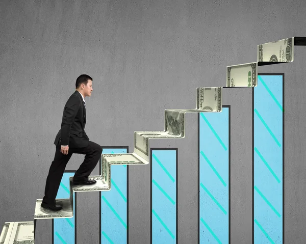 Businessman walking on money stairs with chart — Stock Photo, Image