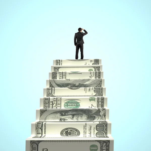 Businessman gazing on top of money stairs — Stock Photo, Image