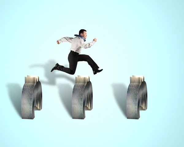 Businessman jumping over euro obstacles — Stock Photo, Image