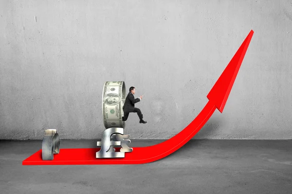 Man jumping through money circle on rising red arrow — Stock Photo, Image