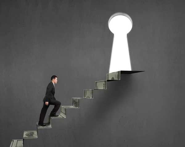 Man climbing on money stairs to key hole — Stock Photo, Image