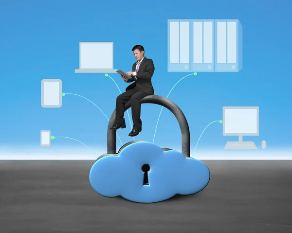 Man sitting on cloud shape lock with device — Stock Photo, Image
