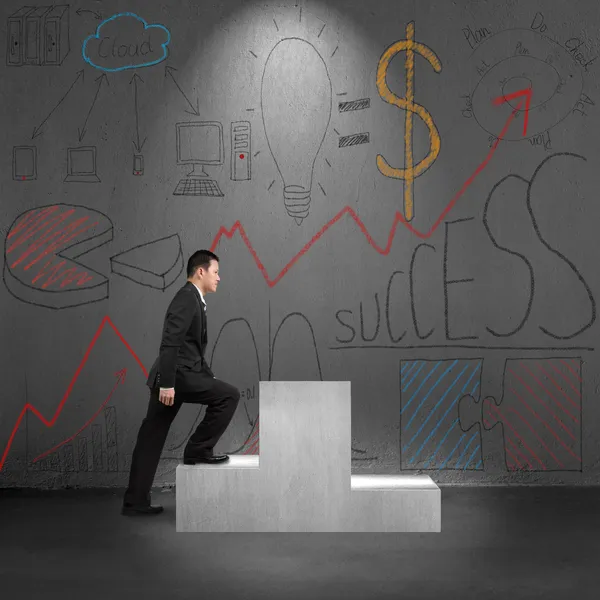 Climbing on podium with business concept doodles on wall — Stock Photo, Image