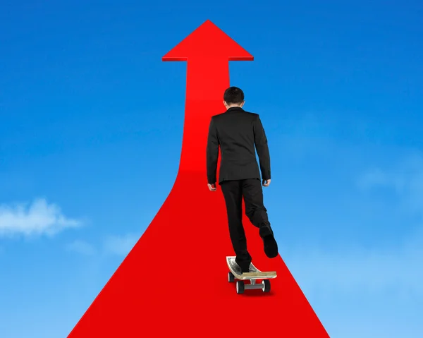 Businessman skateboarding on red arrow in sky — Stock Photo, Image