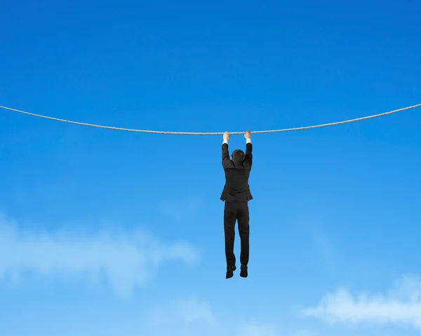 Empresário segurando corda e pendurado no céu — Fotografia de Stock