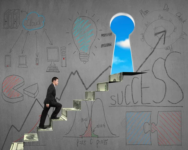 Climbing to key shape door with business doodles on wall — Stock Photo, Image