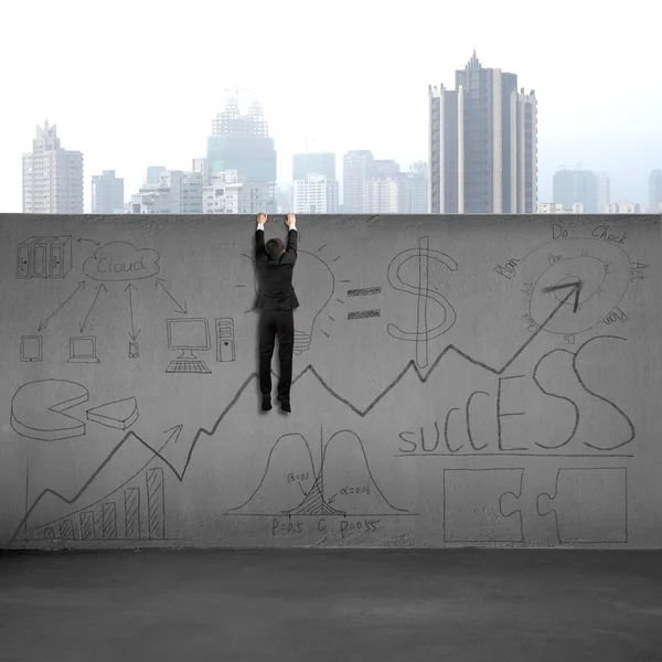 Man climbing over wall with business doodles — Stock Photo, Image