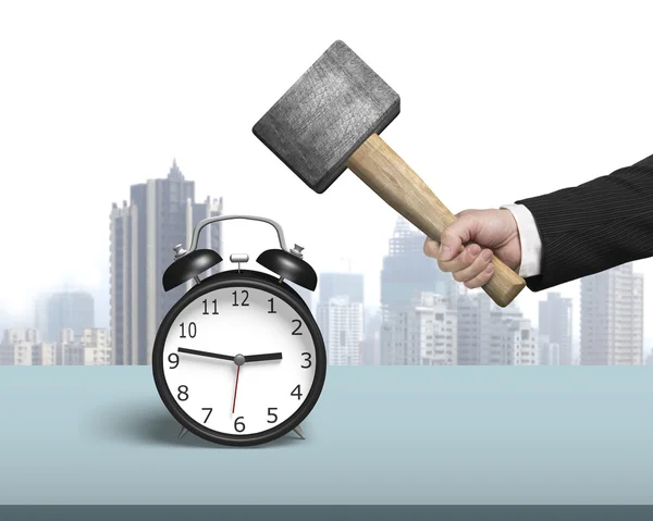 Hitting alarm clock with hammer on table — Stock Photo, Image
