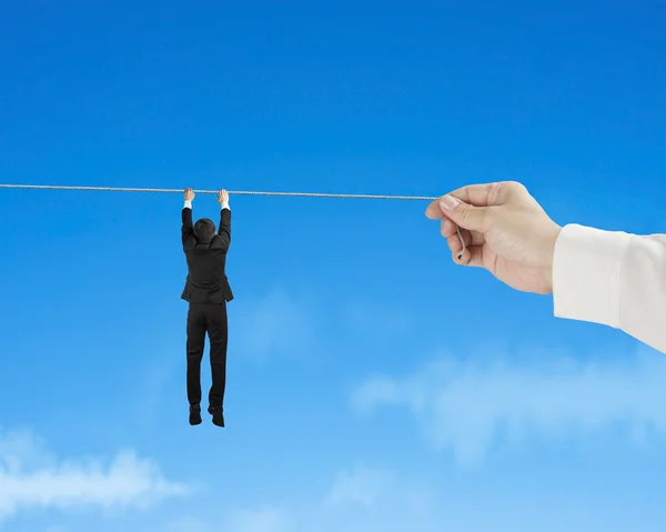 Empresário segurando corda no céu azul — Fotografia de Stock