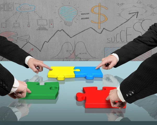 Four men assembling puzzles on table — Stock Photo, Image