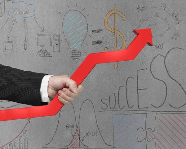 Holding red arrow with business doodles on wall — Stock Photo, Image