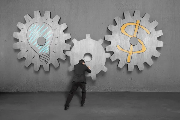 Assembling concrete gears with lamp and money symbol — Stock Photo, Image