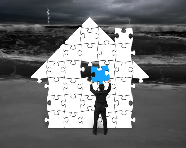 Assembling puzzles in house shape with storm — Stock Photo, Image