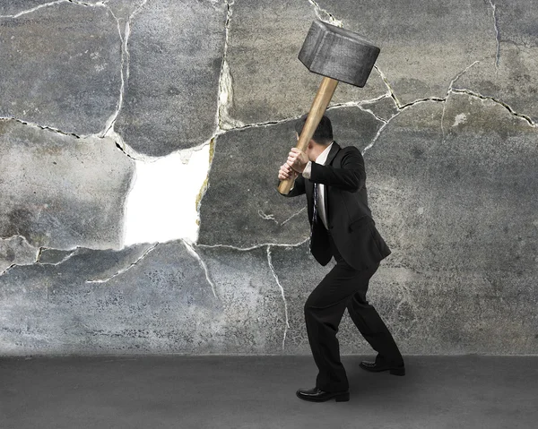 Empresário segurando sedgehammer para quebrar a parede — Fotografia de Stock