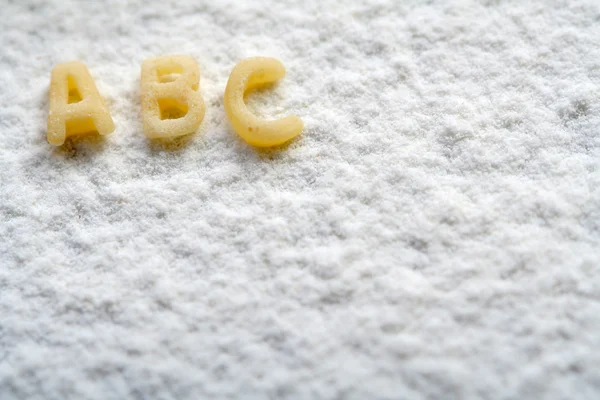 Alfabeto comestível sobre farinha, educação — Fotografia de Stock