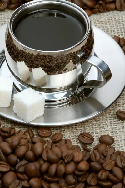 Kopp kaffe med klump socker och bönor — Stockfoto