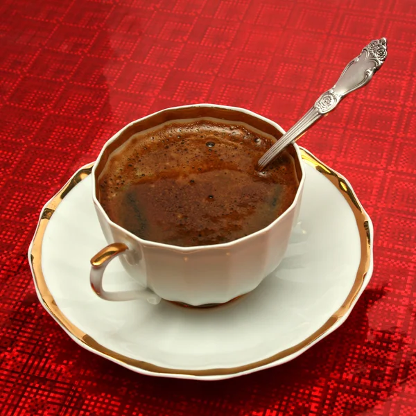 Taza de café con la cuchara sobre fondo rojo — Foto de Stock