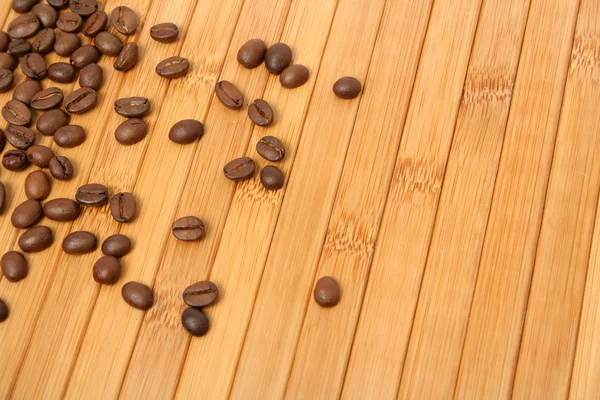 Grains of coffee on a carpet made of a tree — Stock Photo, Image