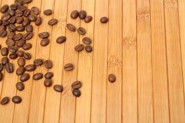 Grains of coffee on a carpet made of a tree — Stock Photo, Image