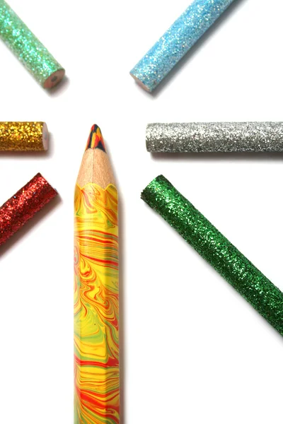 Многоцветный большой карандаш окружен цветными карандашами — стоковое фото