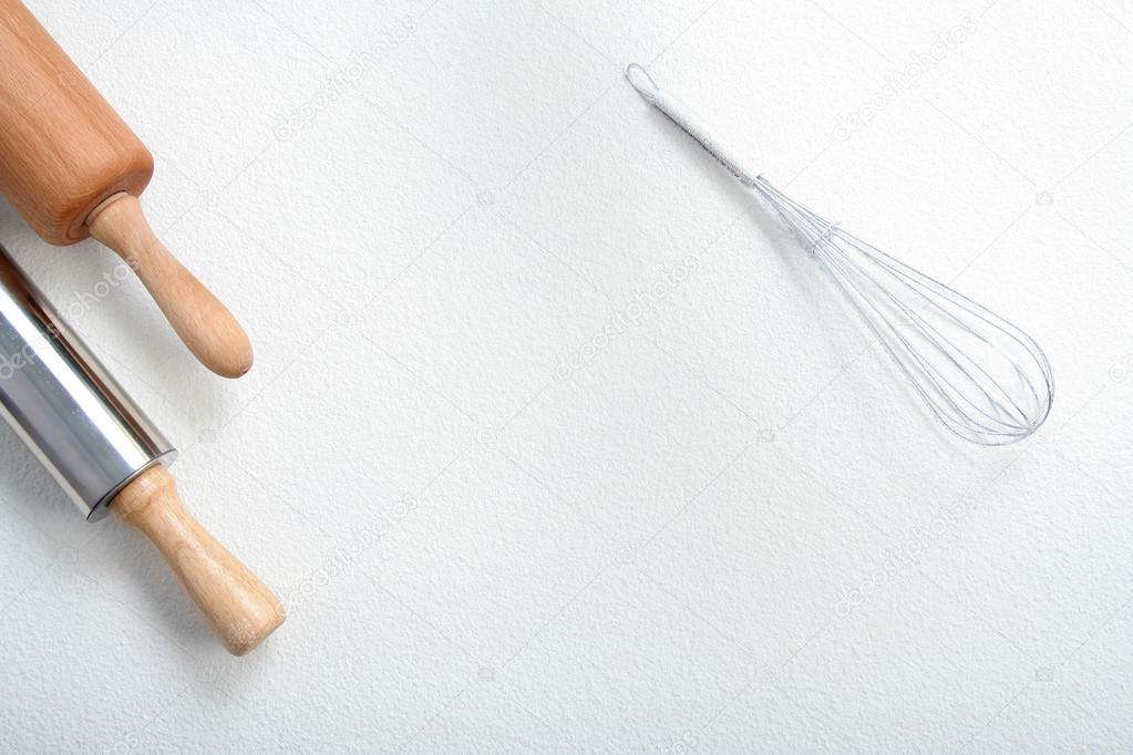 Wire whisk and rolling pin on flour