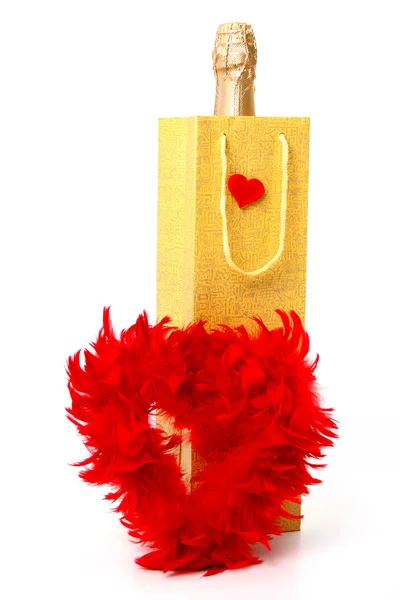 Şişe şampanya ve kalp kırmızı tüyleri yapılmış — Stok fotoğraf