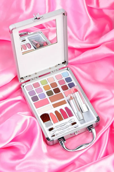 Портфель для макияжа на розовом атласе — стоковое фото