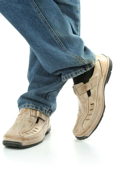 Mänsklig fot med brunt läderskor och jeans — Stockfoto