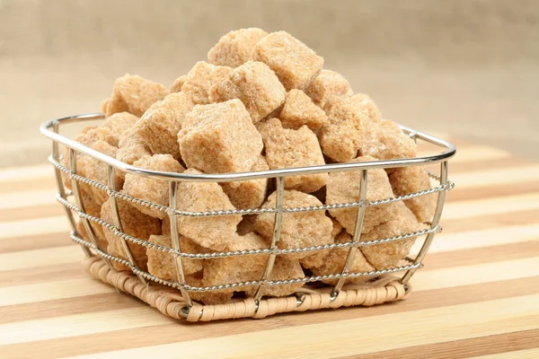 Heap of not refined brown reed sugar in a basket — Stock Photo, Image