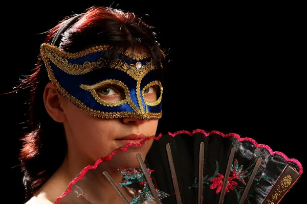 Young brunette with venetian mask and spanish fan — Stock Photo, Image