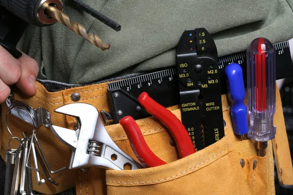 Man with drill and tool belt — Stock Photo, Image