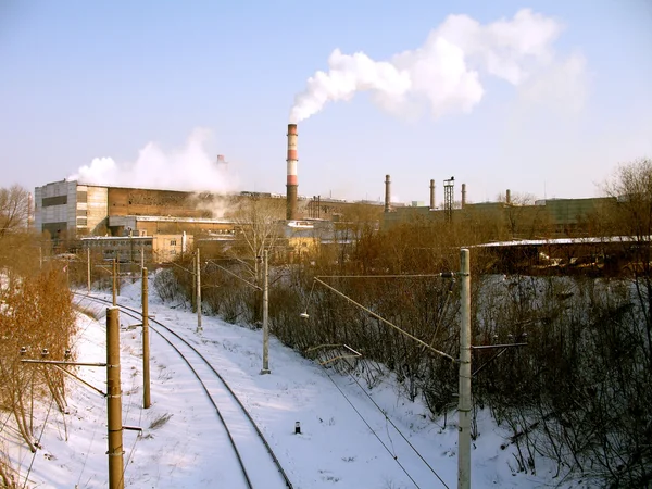 Łóżko kolejowych pokryta śniegiem w pobliżu zakładu metalurgicznego — Zdjęcie stockowe