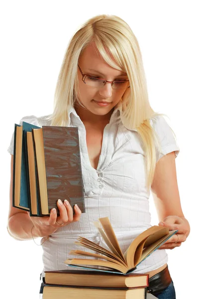 Mladá dívka se naklonil nad hromadou knih — Stock fotografie