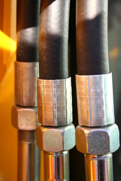 The chromeplated nuts and the reinforced hoses of hydraulic — Stock Photo, Image